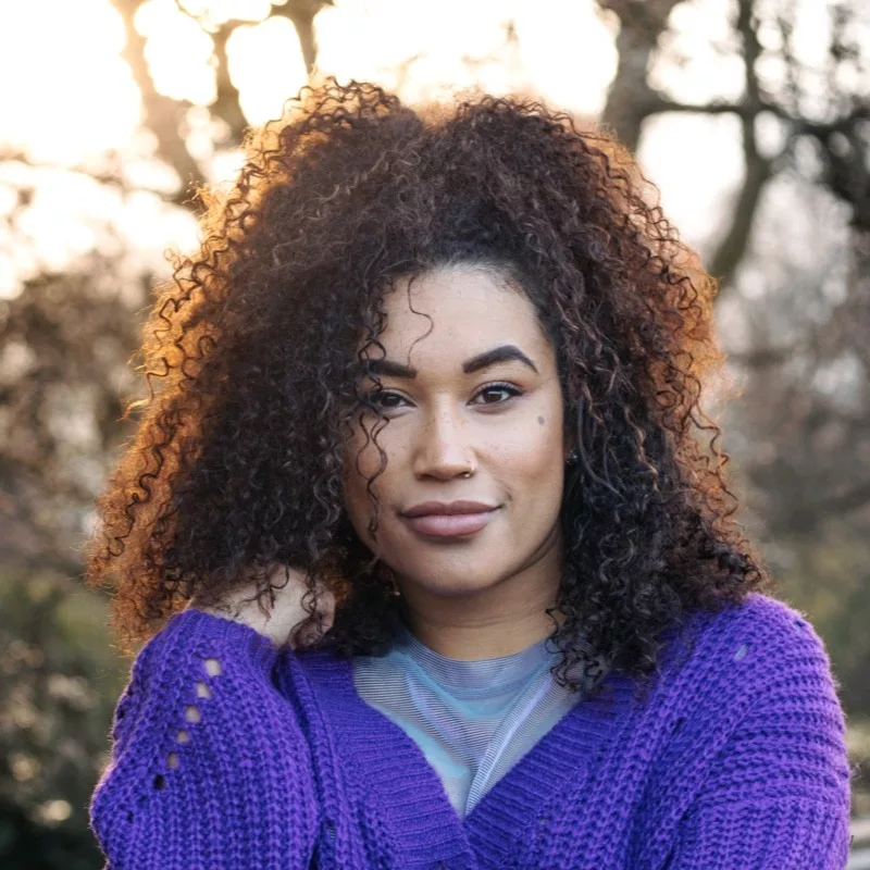 Sinead Campbell is a black woman with long dark curly hair.