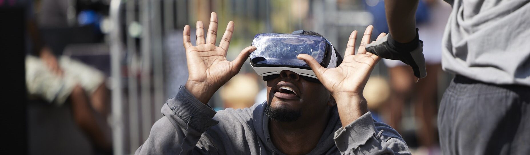 A man wearing a VR headset crouching and looking to the sky