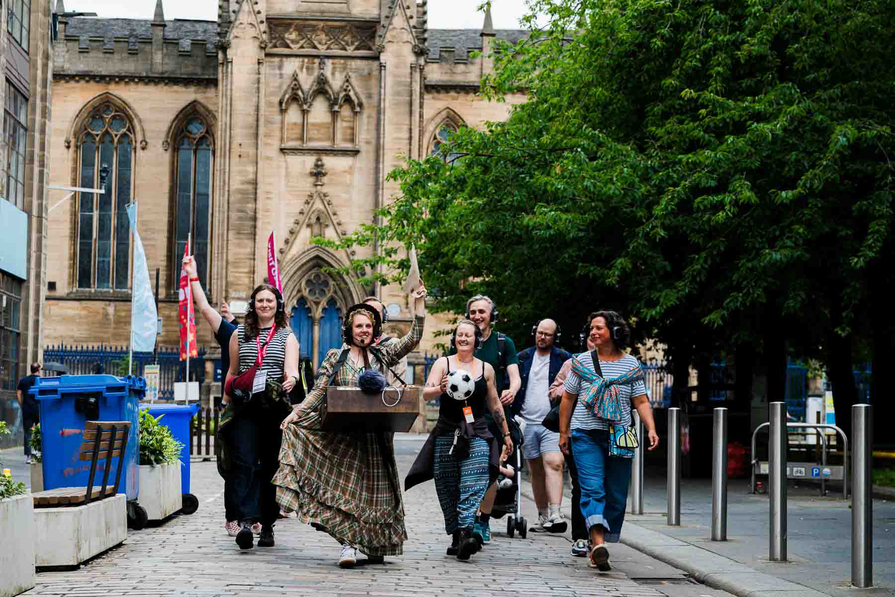 Fran Bundey in character, leading her audience down a street