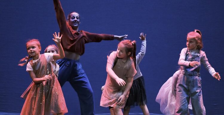 A cast of children dancing on stage