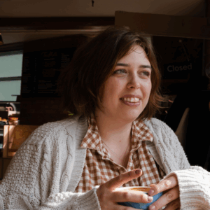 Headshot of Zoe Pickburn, a white woman in her mid-thirties. She has brown hair and eyes.